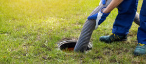 Man pumping out house septic tank. drain and sewage cleaning service.