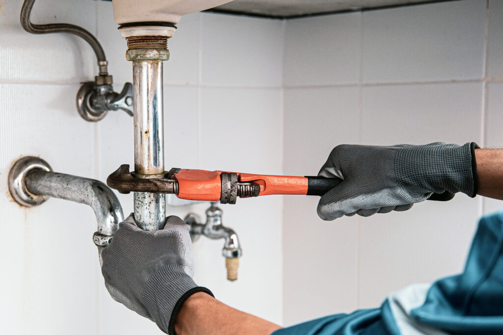 Technician Plumber Using A Wrench To Repair A Water Pipe